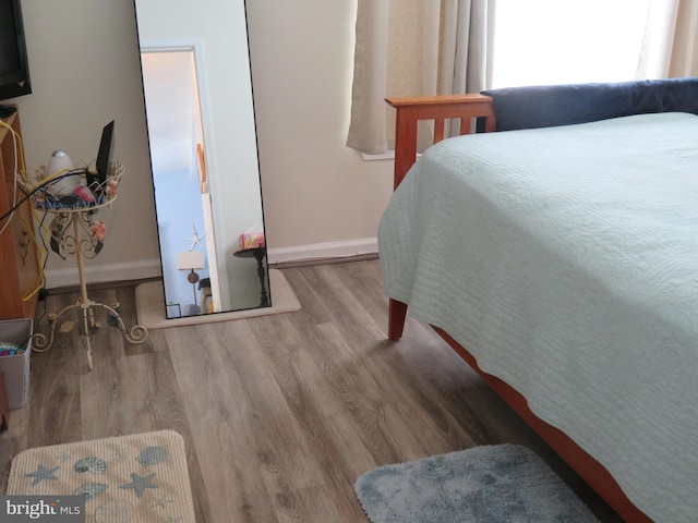 bedroom featuring wood finished floors and baseboards