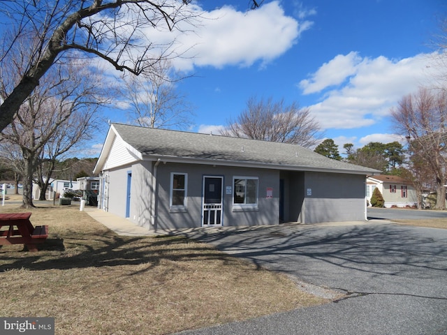 view of front facade with roof with shingles