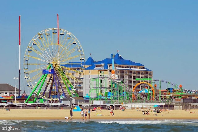 view of playground with a water view and a beach view