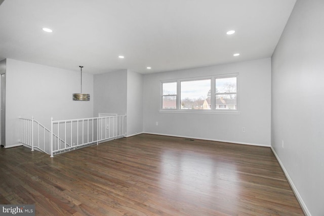 empty room featuring baseboards, wood finished floors, and recessed lighting