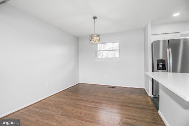 unfurnished dining area with dark wood-style floors, visible vents, baseboards, and recessed lighting