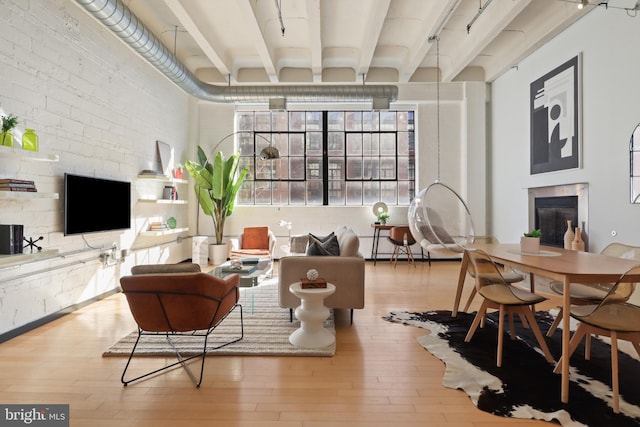 interior space featuring beam ceiling, a fireplace, and wood finished floors