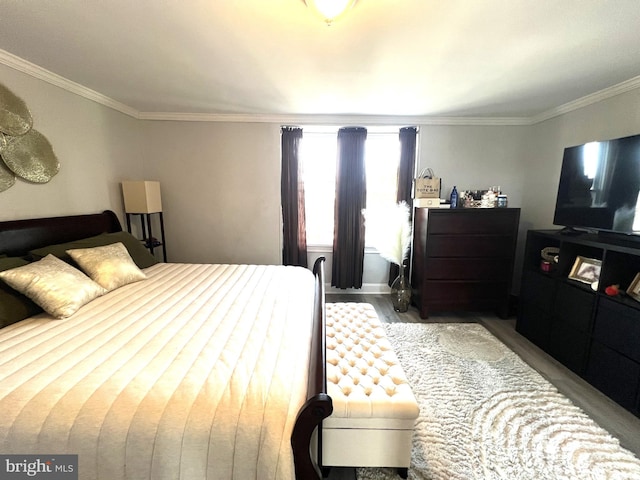 bedroom with crown molding and wood finished floors