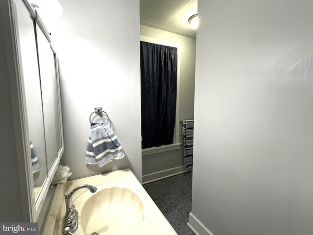 bathroom with a sink and baseboards