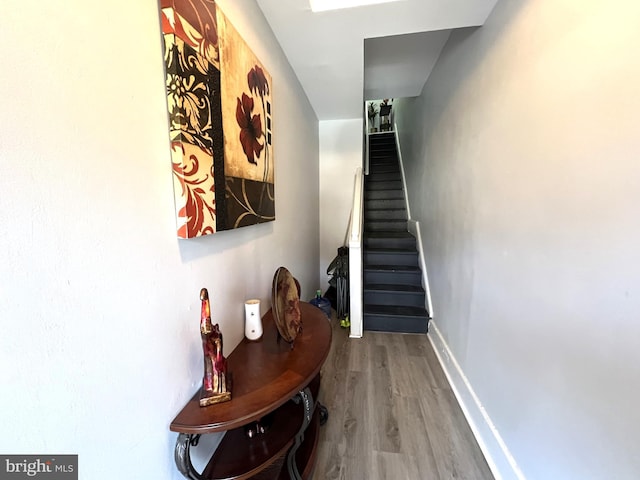 interior space with stairs, baseboards, and wood finished floors