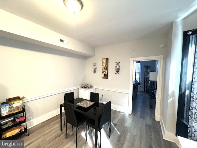 dining room with wood finished floors, visible vents, and baseboards