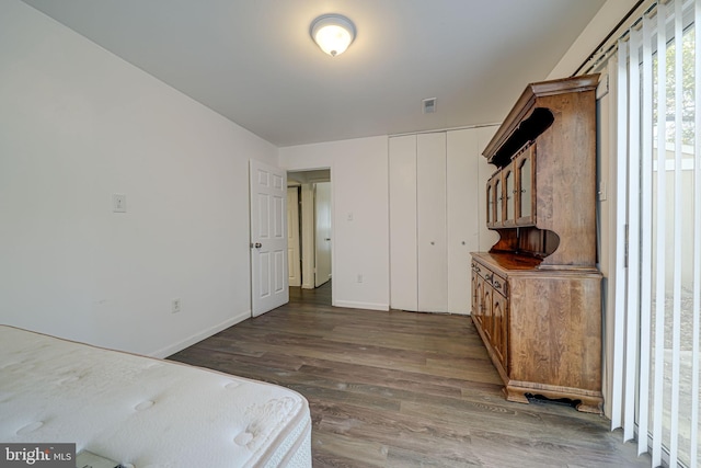 bedroom featuring wood finished floors, visible vents, and baseboards