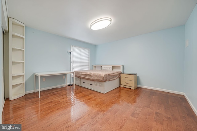 unfurnished bedroom featuring baseboards and wood finished floors