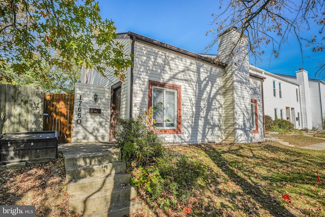 exterior space featuring a chimney and fence