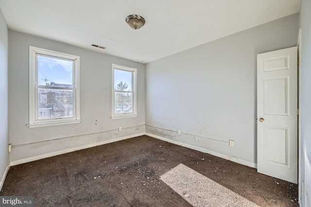 unfurnished room featuring baseboards and visible vents