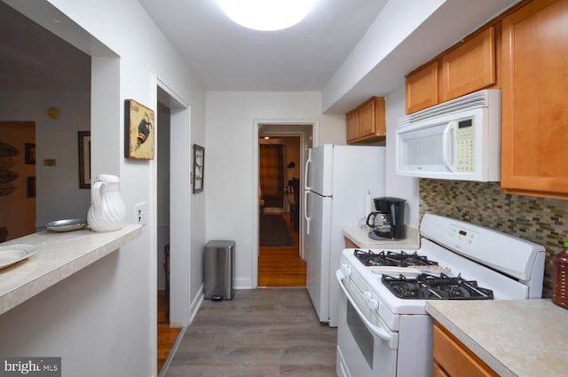 kitchen with brown cabinetry, white appliances, and light countertops