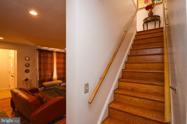 staircase with wood finished floors and recessed lighting