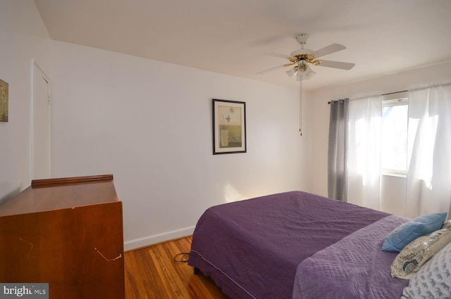 bedroom with ceiling fan, baseboards, and wood finished floors