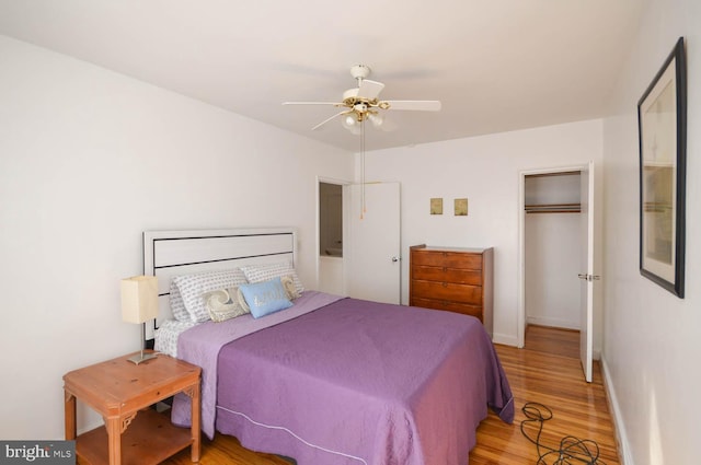 bedroom with ceiling fan, wood finished floors, and baseboards