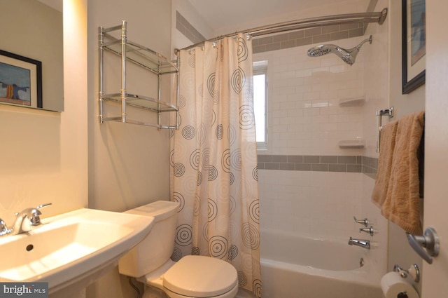 full bathroom with a sink, toilet, and shower / tub combo with curtain