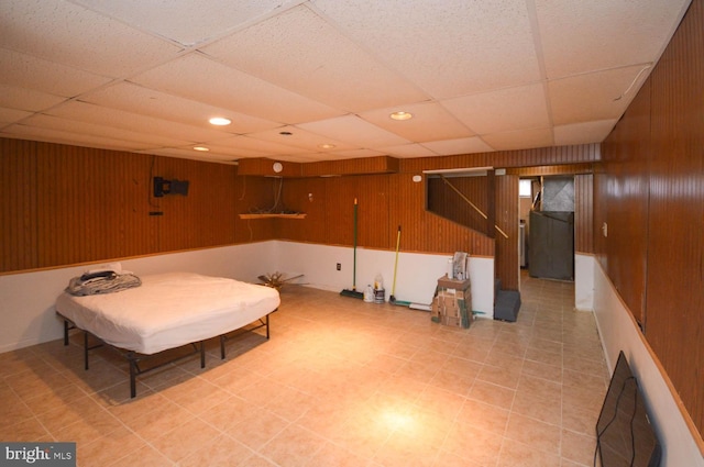 interior space featuring a paneled ceiling, wood walls, and recessed lighting