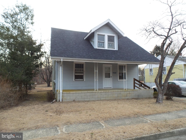 view of front of property with a porch and roof with shingles