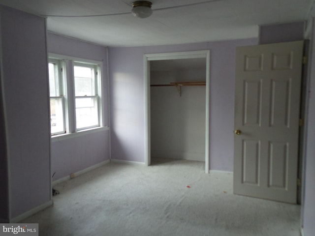 unfurnished bedroom featuring a closet, carpet flooring, and baseboards