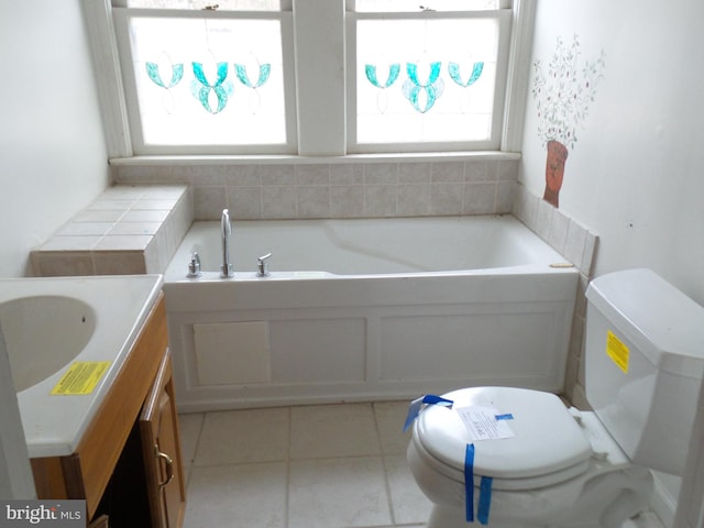 bathroom with toilet, a garden tub, tile patterned floors, and vanity