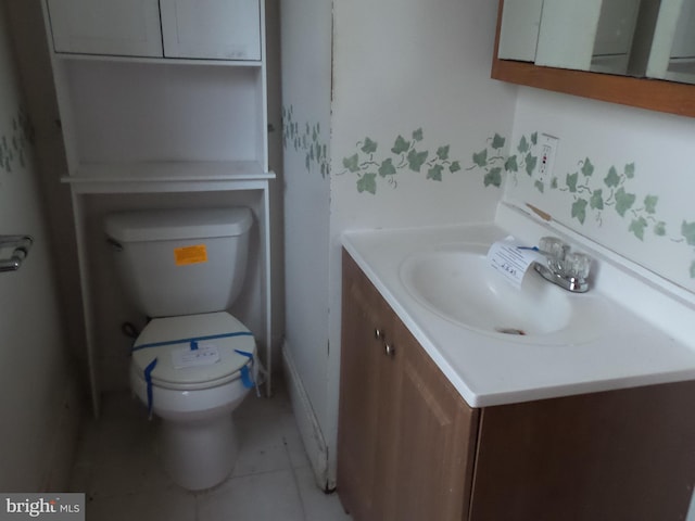 half bath featuring tile patterned flooring, vanity, and toilet