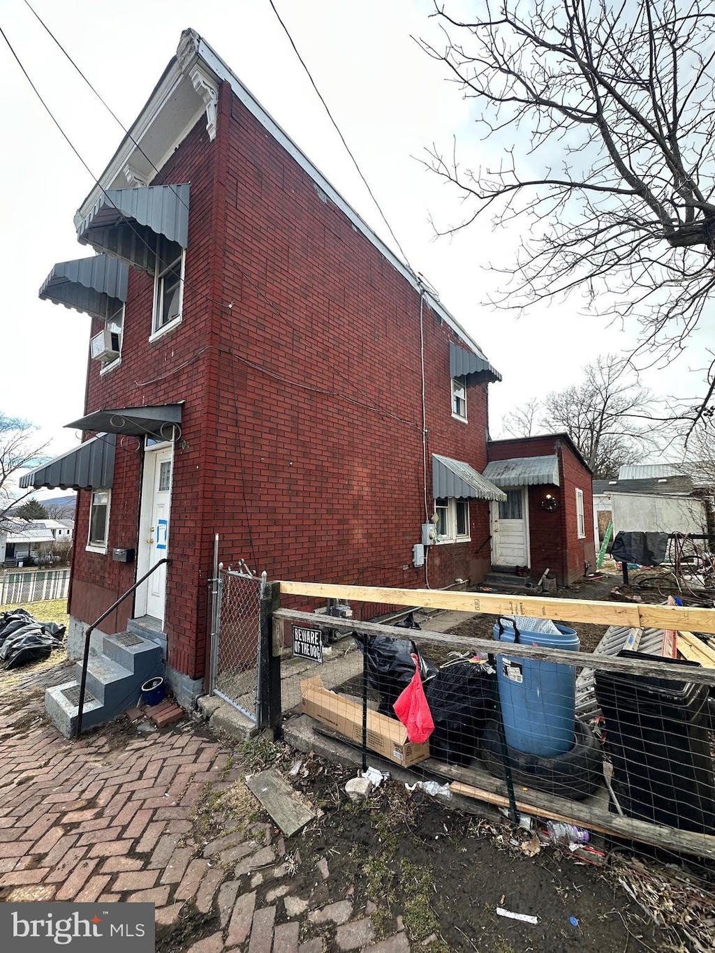 view of home's exterior featuring entry steps, brick siding, cooling unit, and fence