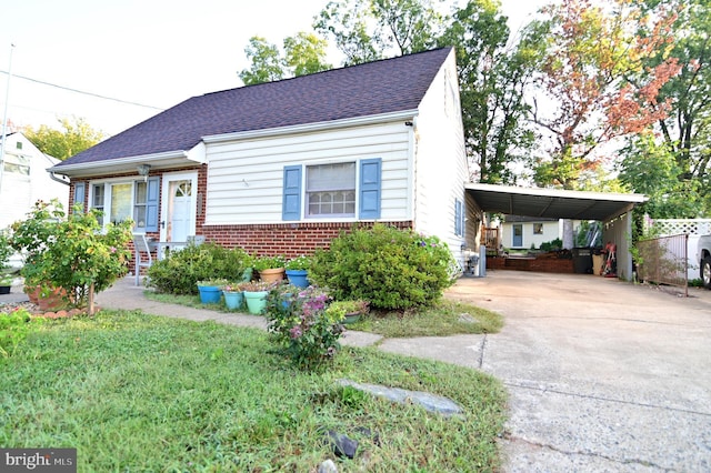 view of front of house featuring brick siding, a shingled roof, fence, concrete driveway, and a carport