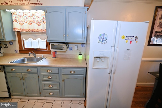 kitchen with white appliances, light countertops, a sink, and decorative backsplash