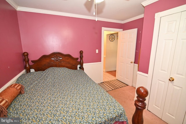 carpeted bedroom with a wainscoted wall and ornamental molding