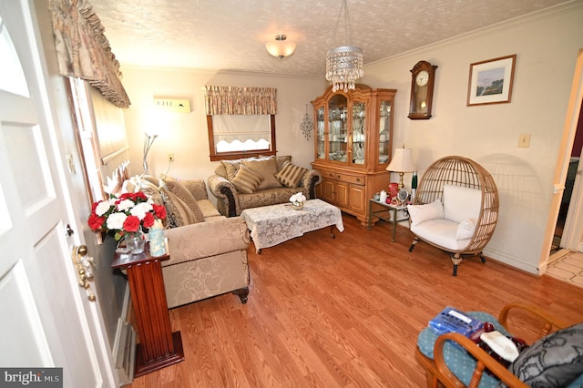 living room with ornamental molding, a textured ceiling, and wood finished floors