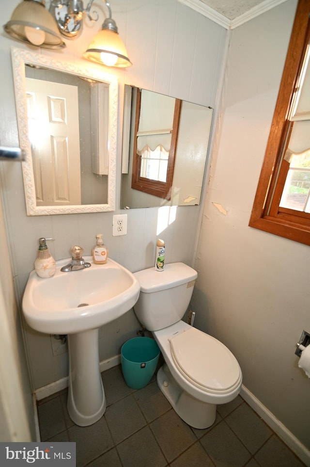 bathroom featuring toilet, tile patterned flooring, a wealth of natural light, and baseboards