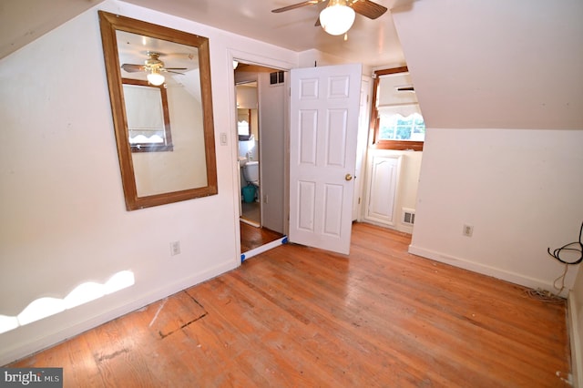 unfurnished bedroom with lofted ceiling, light wood finished floors, baseboards, and visible vents