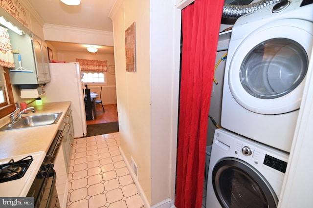 clothes washing area with laundry area, visible vents, crown molding, stacked washing maching and dryer, and a sink