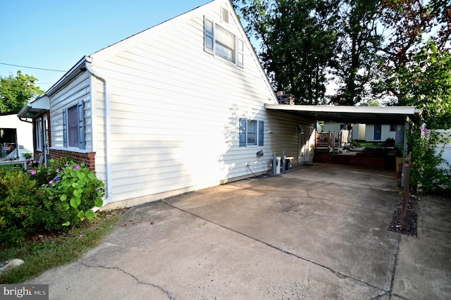 view of home's exterior with driveway, a carport, and brick siding