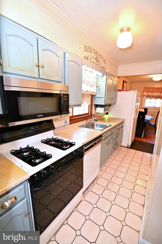 kitchen featuring white appliances, plenty of natural light, a sink, and crown molding