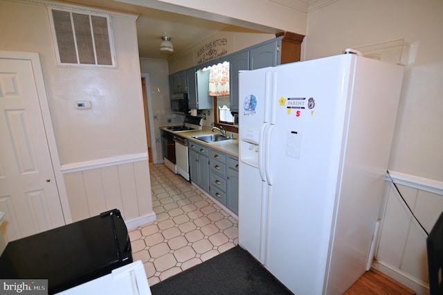 kitchen with visible vents, stainless steel dishwasher, a sink, gas range, and white fridge with ice dispenser