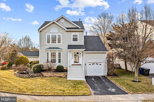 traditional-style house with roof with shingles, driveway, a front lawn, and fence