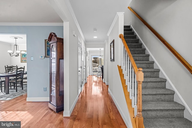 interior space with a chandelier, stairs, ornamental molding, and hardwood / wood-style flooring