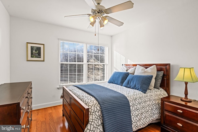 bedroom featuring a ceiling fan, baseboards, and wood finished floors