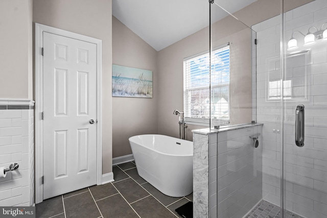 bathroom featuring a stall shower, a freestanding tub, lofted ceiling, and tile patterned floors