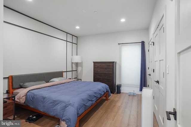 bedroom featuring light wood-type flooring, a closet, and recessed lighting