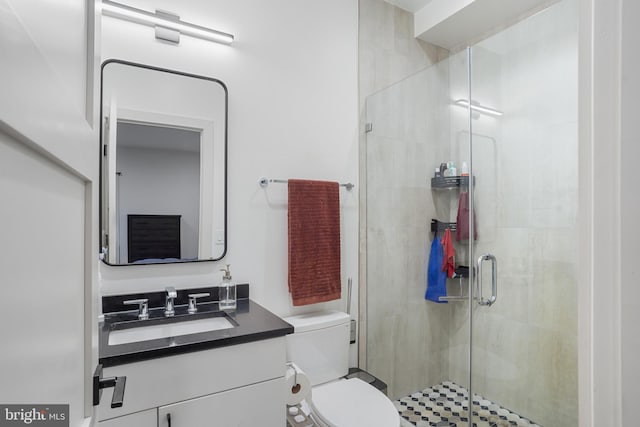 full bathroom featuring toilet, a stall shower, and vanity