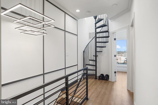 staircase featuring an inviting chandelier, visible vents, wood finished floors, and recessed lighting