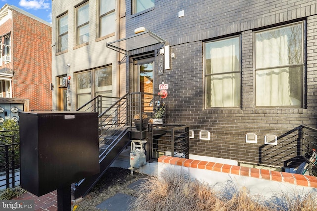 view of exterior entry featuring brick siding