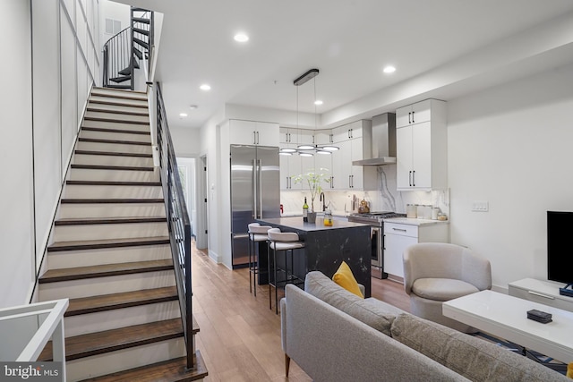 living area featuring stairs, light wood-type flooring, and recessed lighting