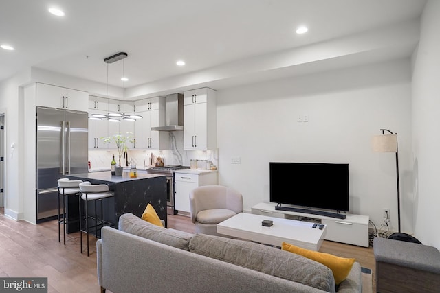 living area with recessed lighting and light wood finished floors