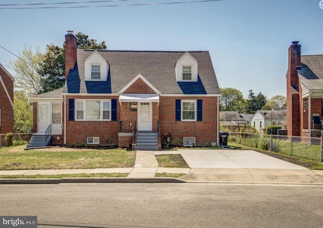 cape cod-style house featuring a front yard, a chimney, fence, and brick siding