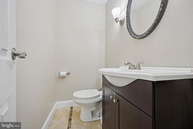 bathroom with baseboards, vanity, toilet, and tile patterned floors