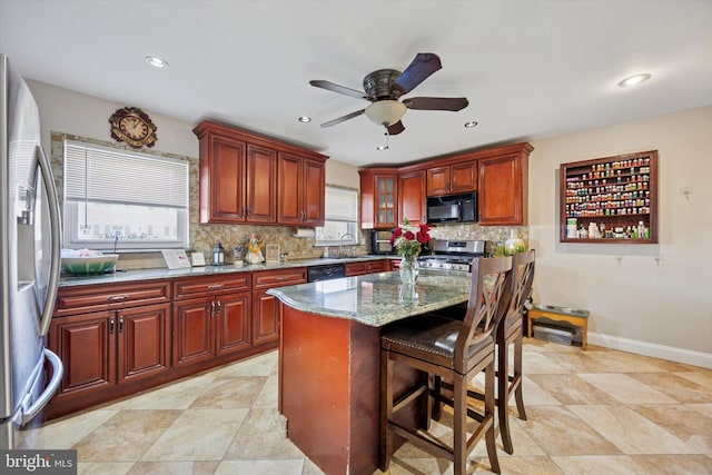 kitchen featuring black appliances, tasteful backsplash, a wealth of natural light, and a sink