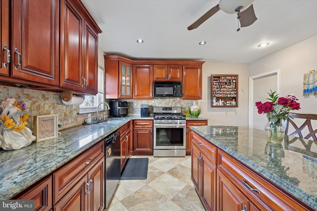 kitchen featuring a sink, backsplash, dark stone counters, black appliances, and glass insert cabinets