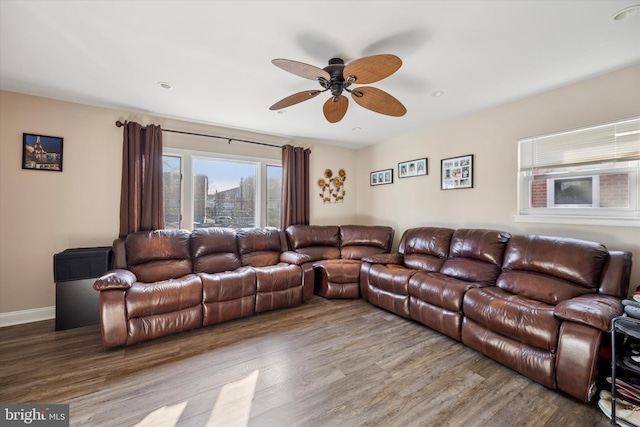 living area featuring ceiling fan, baseboards, a city view, and wood finished floors